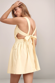 Oat Maeve mini dress back view with open back, wide shoulder straps, tie-back detail, and elastic waist
