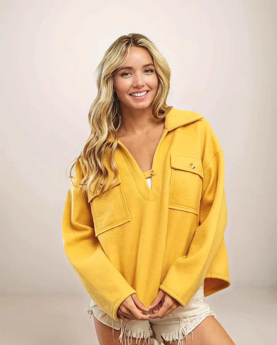 Woman wearing a yellow jacket against a plain background