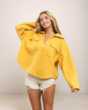 Woman wearing a yellow shirt with a plain background