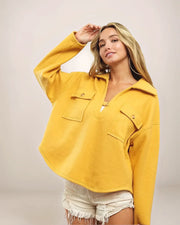 Woman wearing a yellow jacket against a plain background