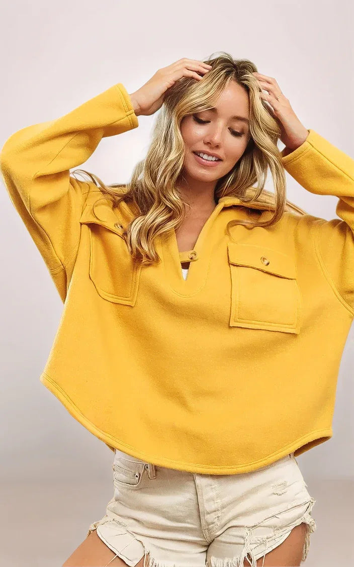 Woman wearing a yellow hoodie with a plain background