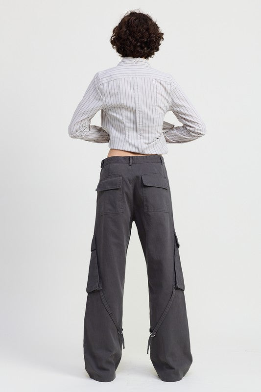 Person wearing gray cargo pants and a striped shirt on a white background