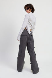 Person wearing a light gray striped shirt and dark gray cargo pants on a white background