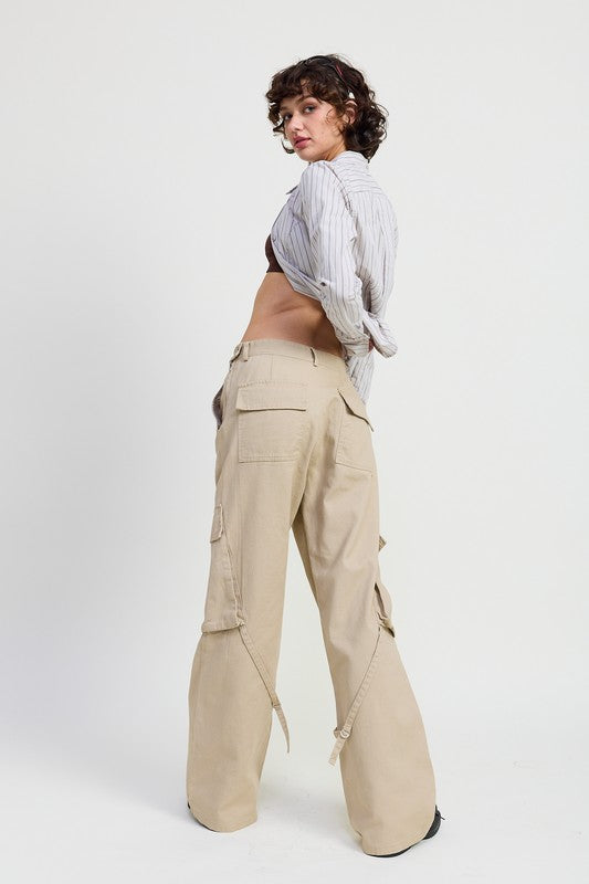 Person wearing beige cargo pants and a white shirt on a white background
