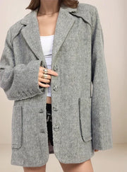 Gray coat worn by a person on a beige background