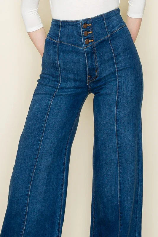 Blue jeans with a button fly on a beige background