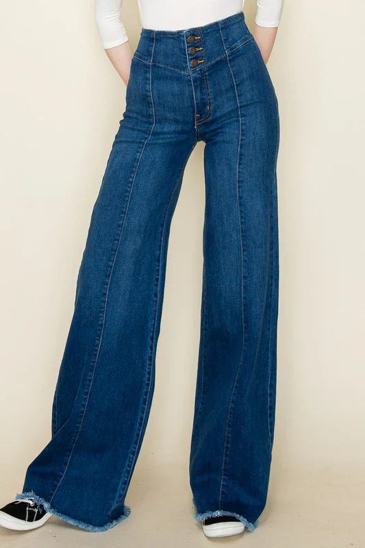 Medium wash high-waisted flare jeans with a 3 button closure, pin tuck seam down the center, and a modern raw hem 