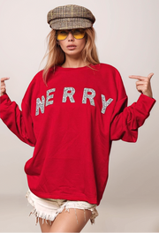 Person wearing a red sweatshirt with 'MERRY' text, sunglasses, and a cap on a plain background