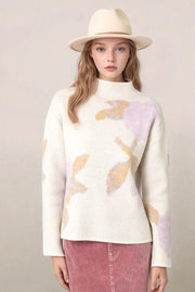 woman wearing an abstract floral sweater with a pink skirt and a hat