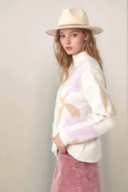 woman wearing abstract floral and cream sweater with a pink skirt