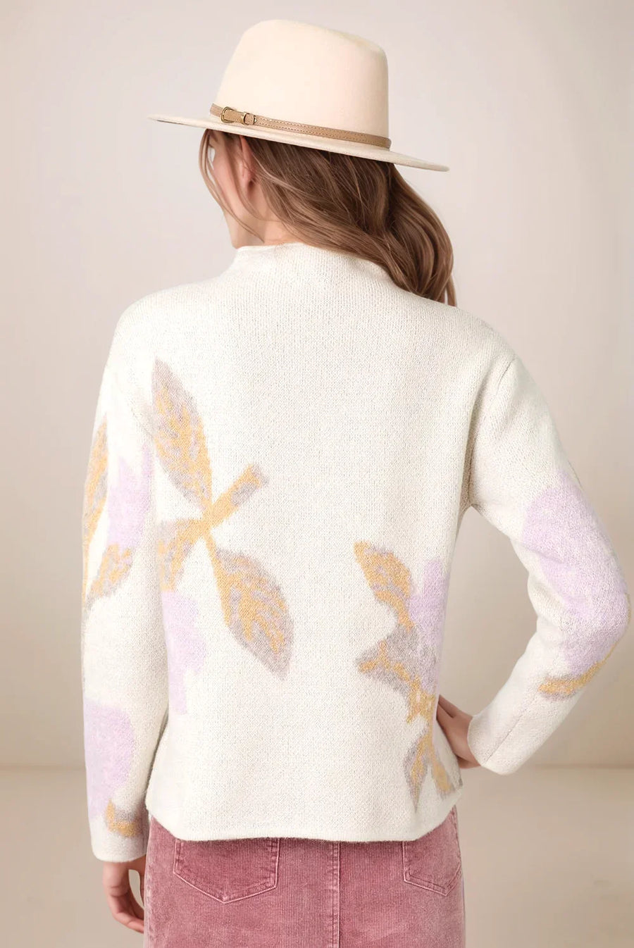 woman wearing an abstract floral sweater facing away from the camera