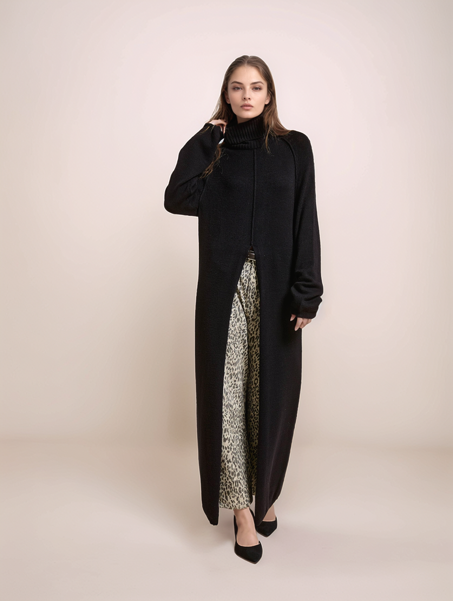 Woman wearing a long black coat over a patterned dress on a beige background