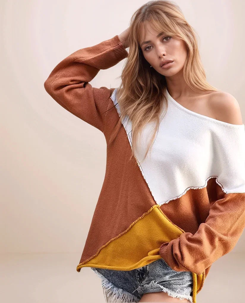 Woman wearing a brown, yellow, and white color-blocked sweater against a beige background