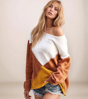 Woman wearing a two-tone sweater with white and brown colors on a plain background