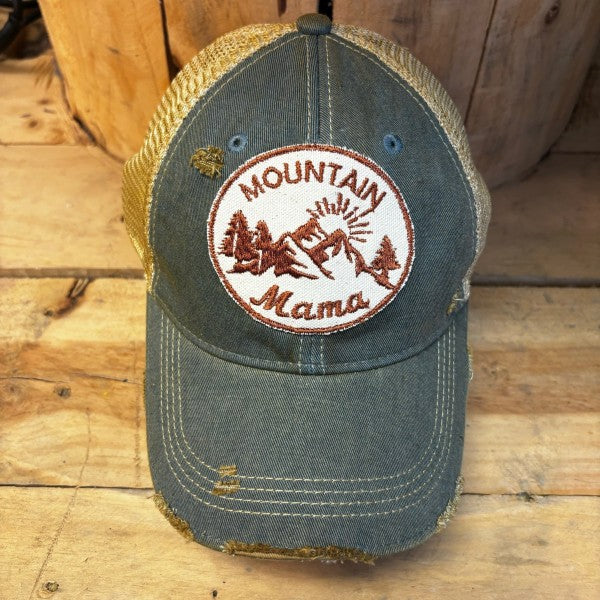 Cap with 'Mountain Mama' patch on a wooden surface