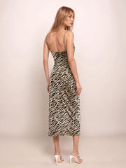 Woman wearing a tiger print dress against a plain background