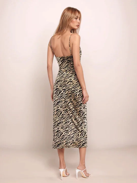 Woman wearing a tiger print dress against a plain background