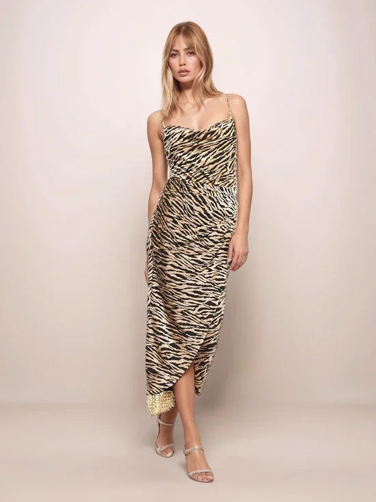 Woman wearing a tiger print dress against a plain background
