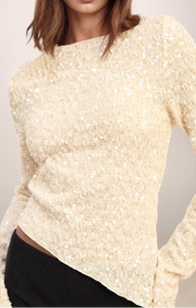 Beige sequin sweater worn by a person on a plain background