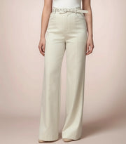 Person wearing white wide-leg pants on a pink background