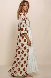 The profile view of a long, openwork cream crochet cardigan with intricate floral patterns and 3/4 sleeves.