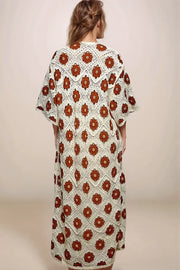 The back view of a long, openwork cream crochet cardigan with intricate floral patterns and 3/4 sleeves.