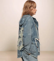 Woman wearing a blue denim jacket with a textured pattern on a beige background