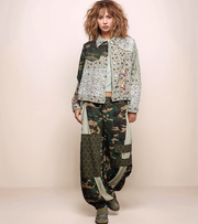 a woman wearing a patchwork jacket with camo pants. 
