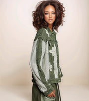 Woman wearing a green floral jacket against a beige background