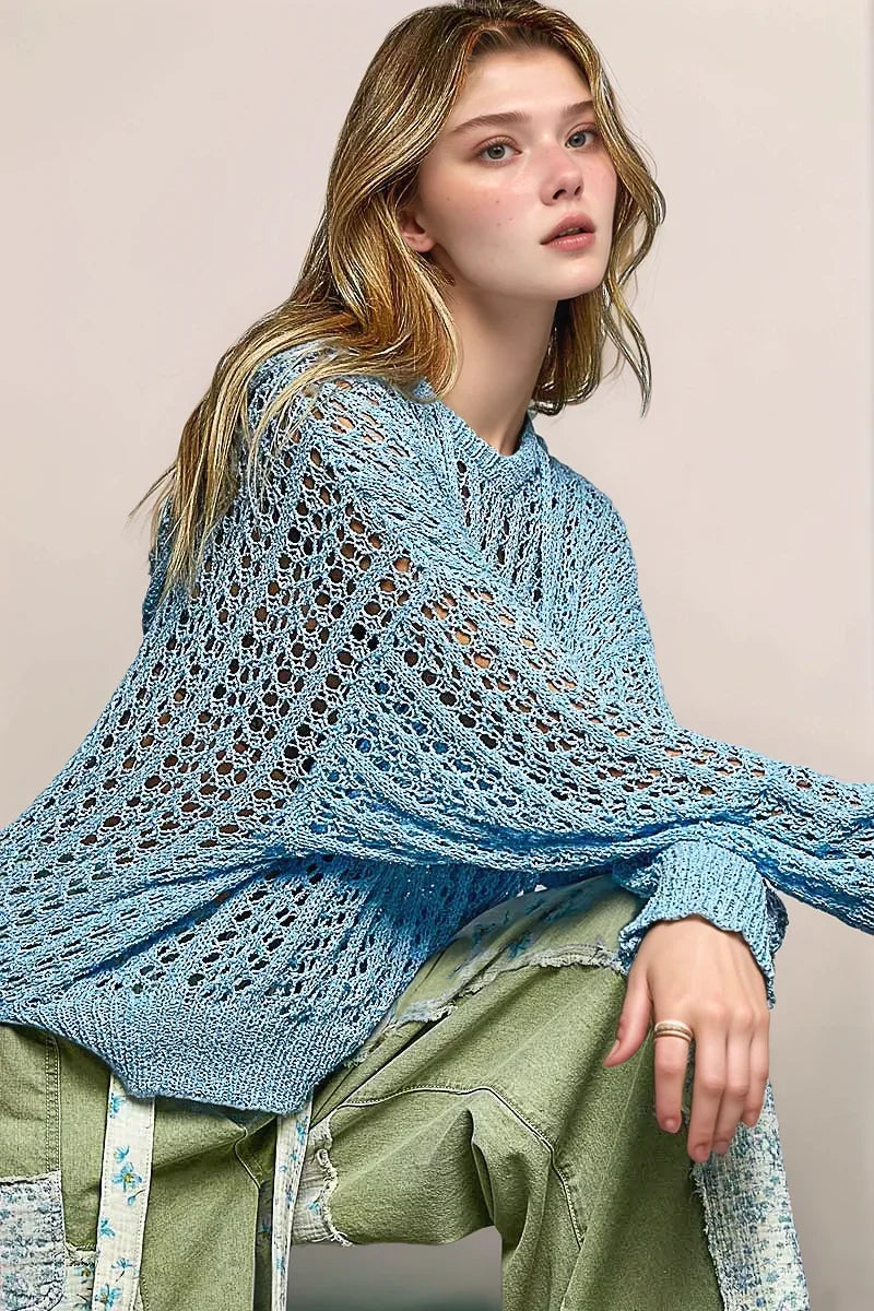 A detailed, angled lifestyle shot of the POL Skye sweater, highlighting the sculptural quality of the knit and its slightly transparent, layering-friendly finish.