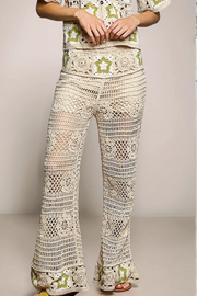 Front view of the cream POL Stardust Star Crochet Pants, highlighting the intricate openwork patterns and the contrasting green star motifs woven into the high-rise waistband.