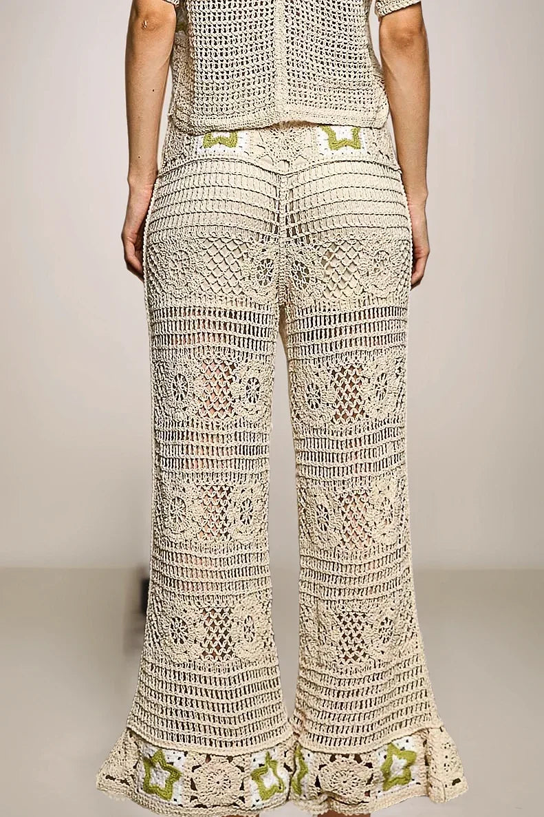 Back view of the cream Stardust crochet bottoms, showcasing the consistent textural knit and the whimsical green star details at the flared ankles.