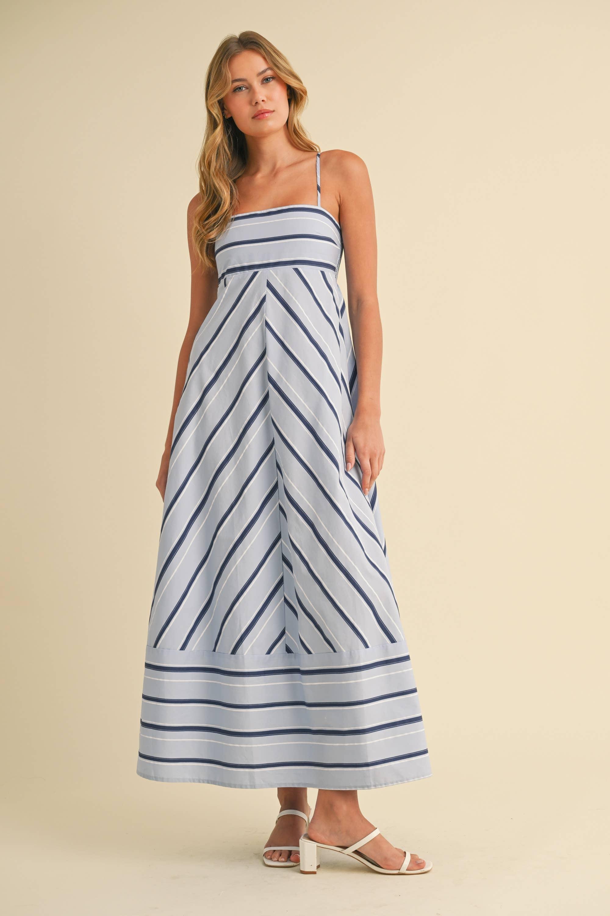 Woman wearing a blue and white striped dress on a beige background