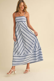 Woman wearing a blue and white striped dress on a beige background