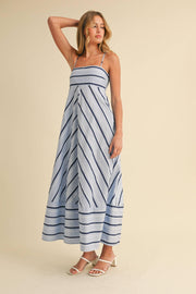 Woman wearing a blue and white striped dress on a beige background