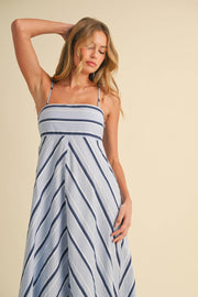 Woman wearing a striped dress against a beige background