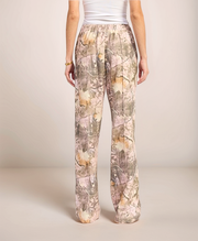 Person wearing camouflage pants on a plain background