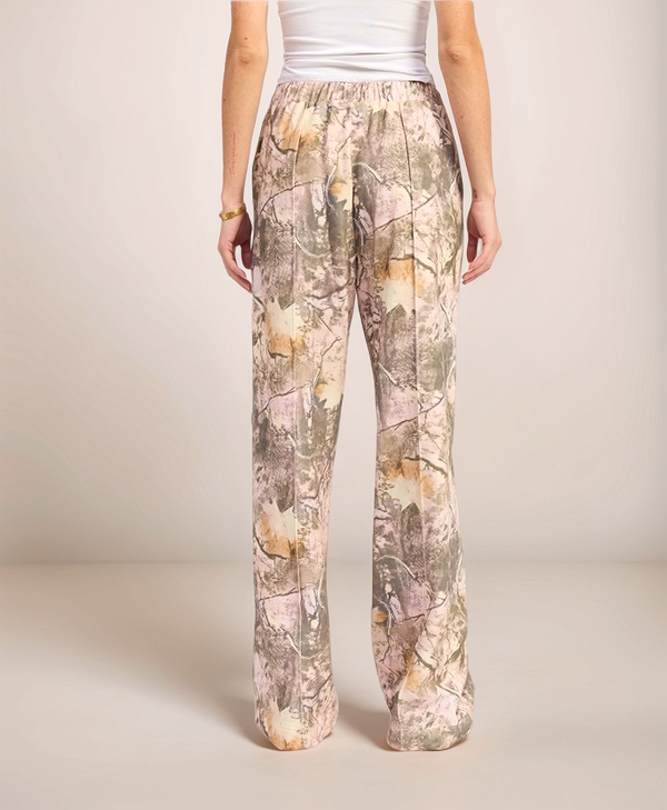 Person wearing camouflage pants on a plain background