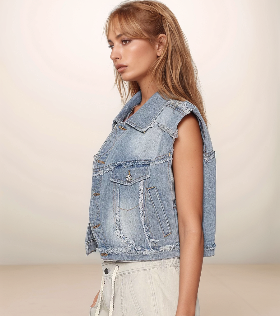 Woman wearing a light blue denim vest against a plain background