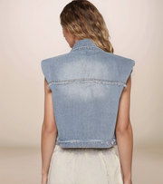 Denim vest worn by a person on a beige background