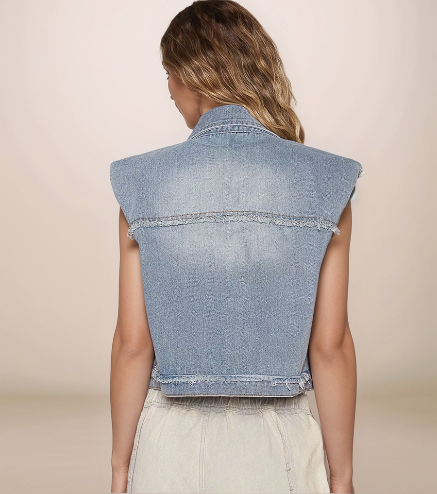 Denim vest worn by a person on a beige background