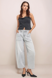 Model wearing RISEN light wash slouchy cropped barrel jeans with front patch pockets and cropped barrel-leg silhouette