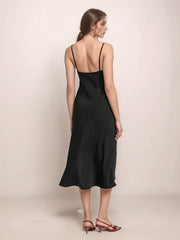 a woman wearing a black dress and red shoes