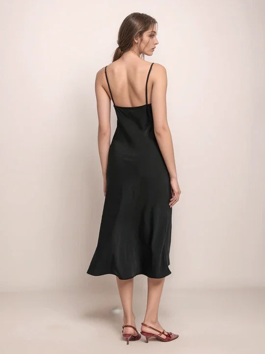 a woman wearing a black dress and red shoes