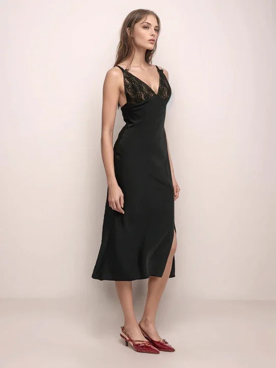 a woman wearing a black slip dress with lace contrast on the bodice with red shoes
