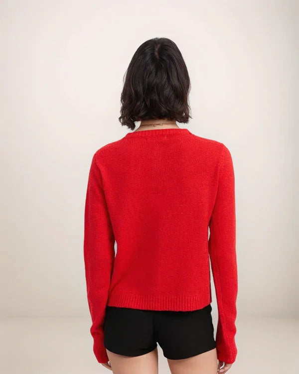 Person wearing a red sweater and black shorts on a plain background
