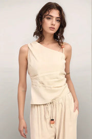 Front view of the natural-colored Sonora Asymmetrical Top, featuring a sophisticated one-shoulder neckline and flattering ruched pleating along the side.