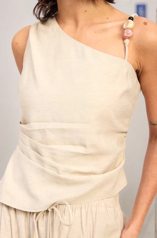 A detailed close-up of the Sonora top's shoulder strap, highlighting the oversized artisanal beads and earth-toned stone embellishments