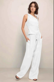 Front view of a model wearing the complete Sonora set in white, featuring the asymmetrical one-shoulder top and baggy wide-leg pants.