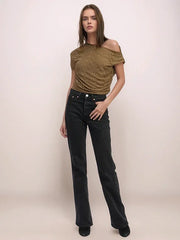 Woman wearing a green off-shoulder top and black jeans on a beige background